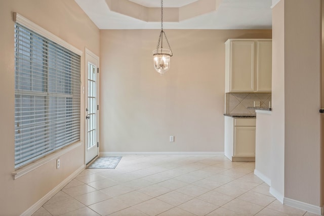 31335 Bearing Star Ln, Tomball, TX 77375 - unfurnished dining area with light tile patterned floors, plenty of natural light, and a tray ceiling