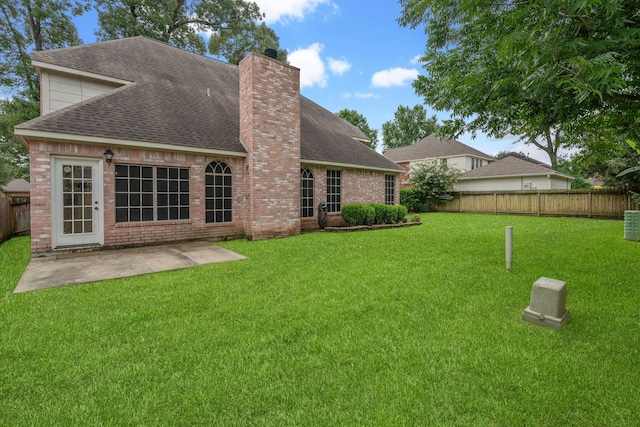 31335 Bearing Star Ln, Tomball, TX 77375 - rear view of property featuring a chimney, a fenced backyard, a shingled roof, a patio, and brick siding