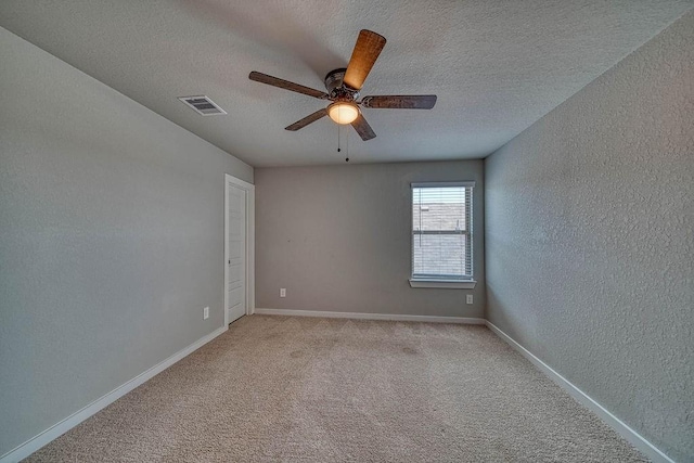 22168 Juniper Crossing Dr, New Caney, TX 77357 - spare room with a textured ceiling, a ceiling fan, baseboards, a textured wall, and light colored carpet