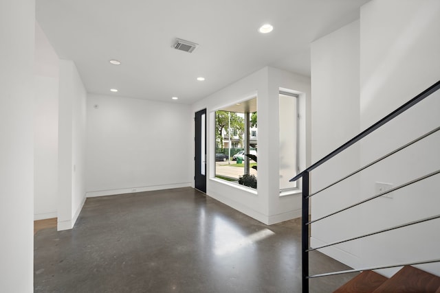 1518 Bayram Dr, Houston, TX 77055 - empty room with finished concrete flooring, recessed lighting, and stairway