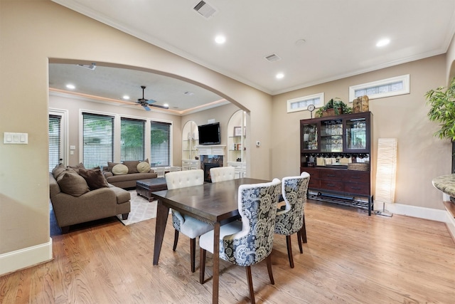 1215 Malone St, Houston, TX 77007 - dining area featuring arched walkways, ornamental molding, a ceiling fan, light wood-style flooring, and baseboards