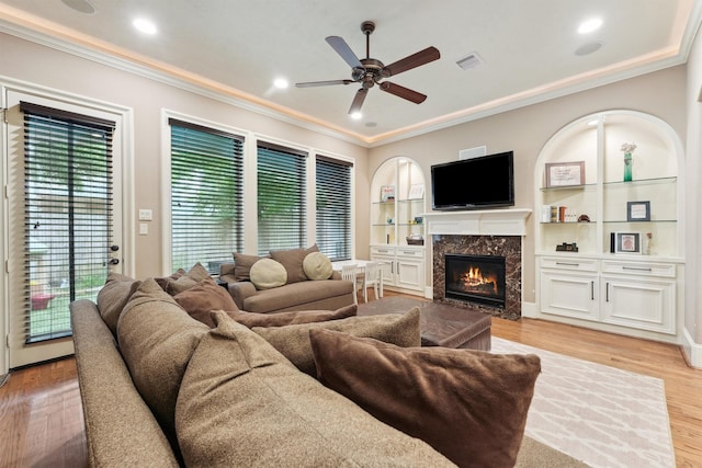1215 Malone St, Houston, TX 77007 - living area with crown molding, ceiling fan, a high end fireplace, light wood-style floors, and built in features