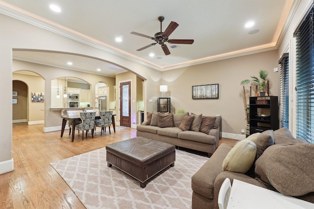 1215 Malone St, Houston, TX 77007 - living room with arched walkways, a ceiling fan, light wood-style flooring, baseboards, and crown molding
