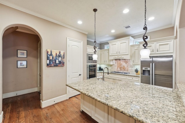 1215 Malone St, Houston, TX 77007 - kitchen with stainless steel appliances, a sink, crown molding, light stone counters, and decorative backsplash