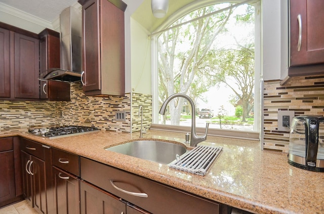 7103 Adobe Meadows Ct, Sugar Land, TX 77479 - kitchen featuring stainless steel gas cooktop, wall chimney range hood, a sink, light stone countertops, and ornamental molding