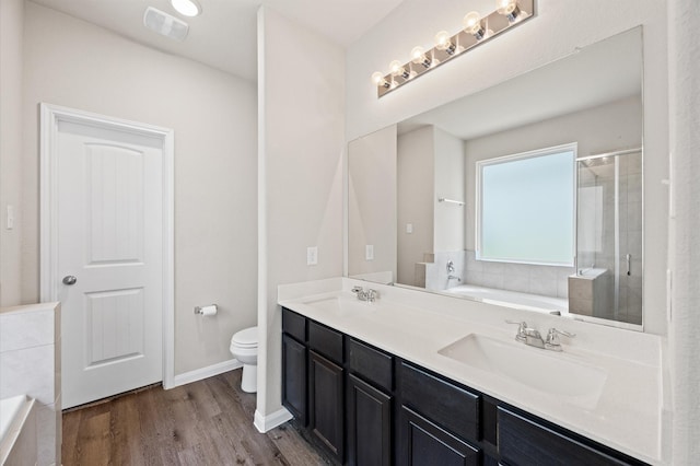 14008 Paddlefish Dr, Conroe, TX 77384 - full bathroom featuring double vanity, a garden tub, a stall shower, and wood finished floors
