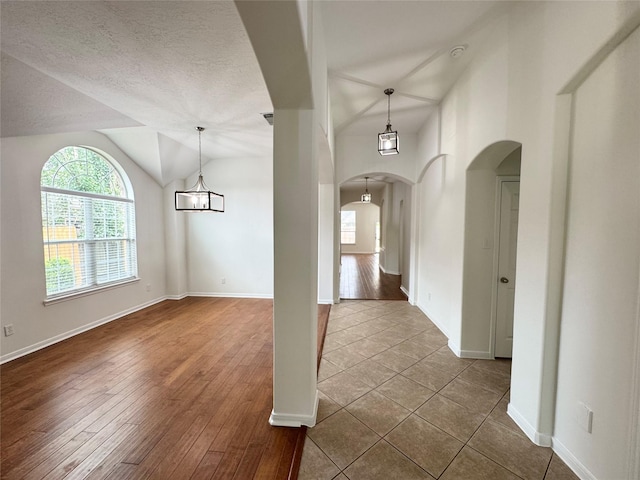 30611 Pinemill Hollow Dr, Spring, TX 77386 - foyer entrance featuring arched walkways, lofted ceiling, baseboards, a textured ceiling, and dark wood-style floors