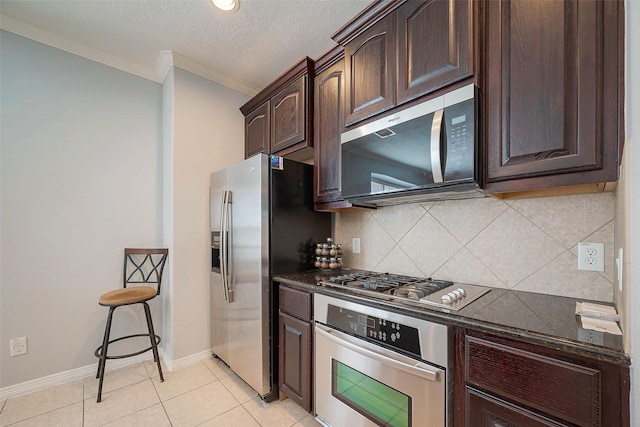 3426 Skyline Village Dr, Houston, TX 77057 - kitchen with stainless steel appliances, ornamental molding, dark brown cabinets, tasteful backsplash, and baseboards