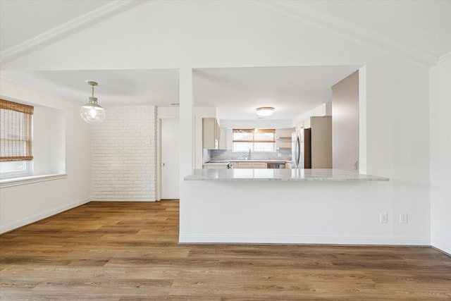 10715 Piping Rock Ln, Houston, TX 77042 - kitchen featuring freestanding refrigerator, vaulted ceiling, wood finished floors, tasteful backsplash, and light stone counters