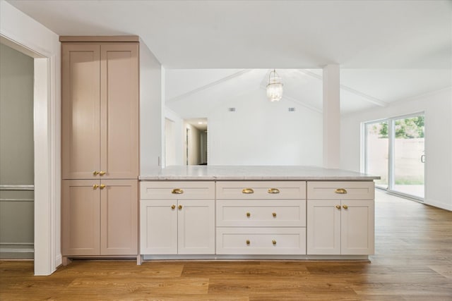 10715 Piping Rock Ln, Houston, TX 77042 - kitchen featuring light wood-style flooring, light stone countertops, vaulted ceiling, and a peninsula