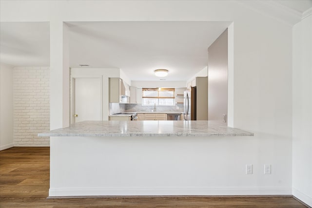 10715 Piping Rock Ln, Houston, TX 77042 - kitchen with stainless steel appliances, a peninsula, a sink, backsplash, and dark wood finished floors