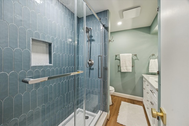 10715 Piping Rock Ln, Houston, TX 77042 - bathroom featuring a shower stall, toilet, vanity, wood finished floors, and baseboards