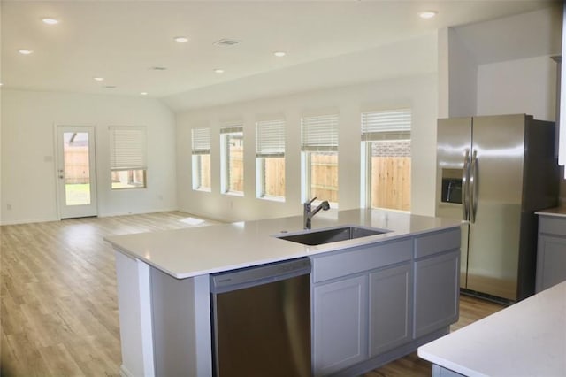 3713 NE River Sand Rd, Rosenberg, TX 77469 - kitchen featuring stainless steel appliances, a sink, open floor plan, a center island with sink, and light wood-style flooring