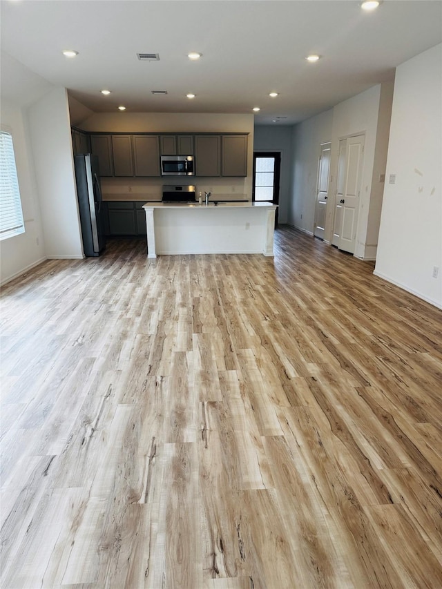 3713 NE River Sand Rd, Rosenberg, TX 77469 - kitchen with appliances with stainless steel finishes, open floor plan, light wood-style floors, recessed lighting, and baseboards