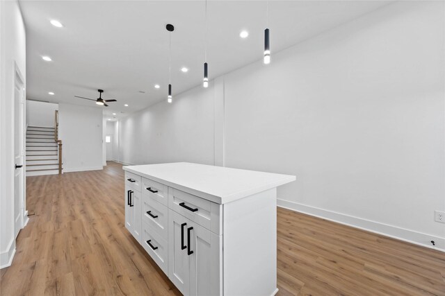 7719 Orebo St, Houston, TX 77088 - kitchen with light wood finished floors, a ceiling fan, white cabinetry, hanging light fixtures, and recessed lighting