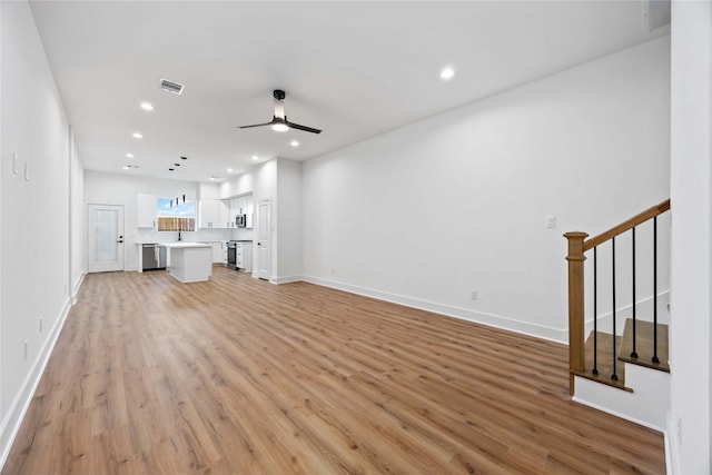 7719 Orebo St, Houston, TX 77088 - unfurnished living room with ceiling fan, light wood-style flooring, stairway, recessed lighting, and baseboards