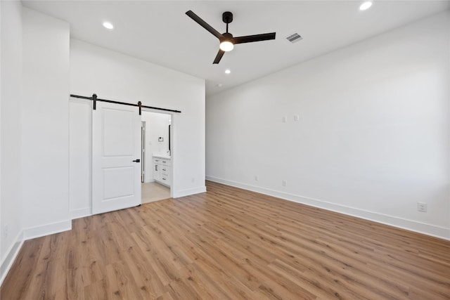 7719 Orebo St, Houston, TX 77088 - unfurnished bedroom featuring a barn door, light wood finished floors, baseboards, and recessed lighting