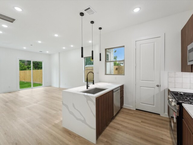 7416 Maxroy St, Houston, TX 77088 - kitchen with a sink, appliances with stainless steel finishes, a peninsula, light wood-type flooring, and tasteful backsplash
