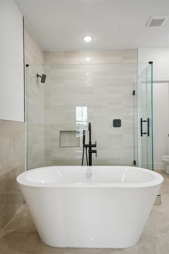 7416 Maxroy St, Houston, TX 77088 - full bathroom featuring tile walls, a stall shower, a freestanding bath, recessed lighting, and marble finish flooring