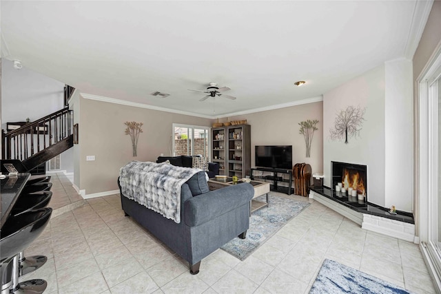 16019 Juniper Grove Dr, Houston, TX 77084 - living room with stairs, ornamental molding, ceiling fan, a lit fireplace, and light tile patterned floors