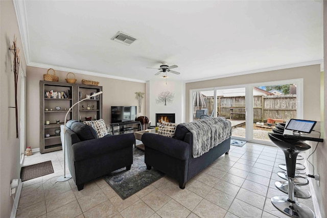 16019 Juniper Grove Dr, Houston, TX 77084 - living area with crown molding, a lit fireplace, a ceiling fan, and light tile patterned floors