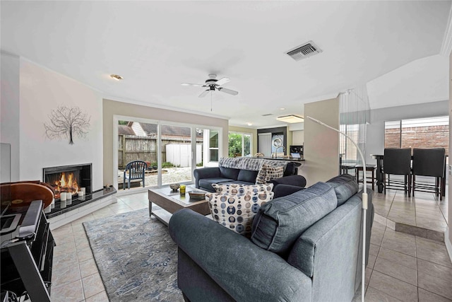 16019 Juniper Grove Dr, Houston, TX 77084 - living area with light tile patterned flooring, ceiling fan, and a warm lit fireplace