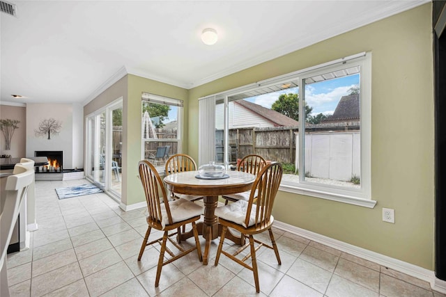 16019 Juniper Grove Dr, Houston, TX 77084 - dining area with ornamental molding, a lit fireplace, baseboards, and light tile patterned floors