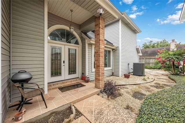 16019 Juniper Grove Dr, Houston, TX 77084 - view of exterior entry featuring french doors, central air condition unit, and a security system