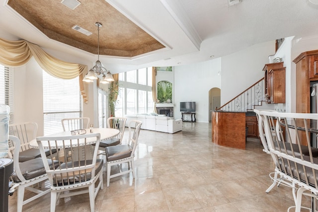 16206 Lobo Ln, Spring, TX 77379 - dining area with a chandelier, stairway, arched walkways, a raised ceiling, and ornamental molding