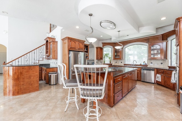 16206 Lobo Ln, Spring, TX 77379 - kitchen with appliances with stainless steel finishes, a center island, healthy amount of natural light, arched walkways, and recessed lighting