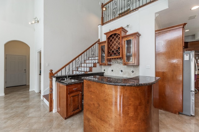 16206 Lobo Ln, Spring, TX 77379 - indoor bar with a towering ceiling, arched walkways, stairway, freestanding refrigerator, and tasteful backsplash