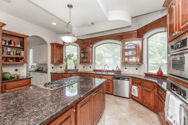 16206 Lobo Ln, Spring, TX 77379 - kitchen with appliances with stainless steel finishes, a sink, crown molding, tasteful backsplash, and glass insert cabinets