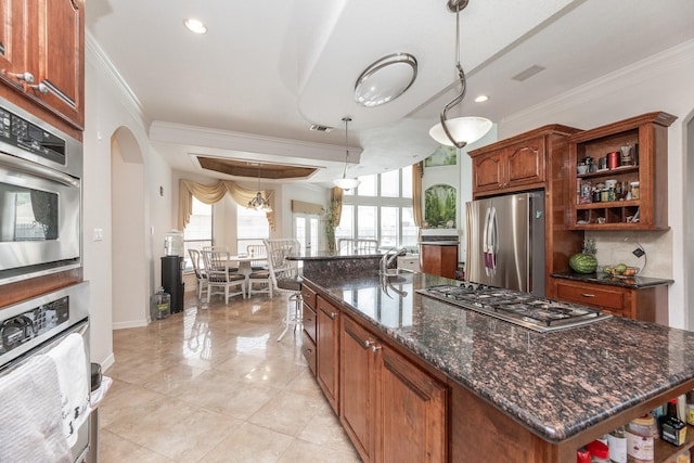 16206 Lobo Ln, Spring, TX 77379 - kitchen featuring appliances with stainless steel finishes, ornamental molding, open shelves, an island with sink, and arched walkways