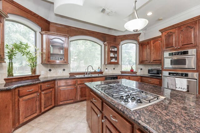16206 Lobo Ln, Spring, TX 77379 - kitchen with stainless steel appliances, a sink, glass insert cabinets, decorative backsplash, and crown molding