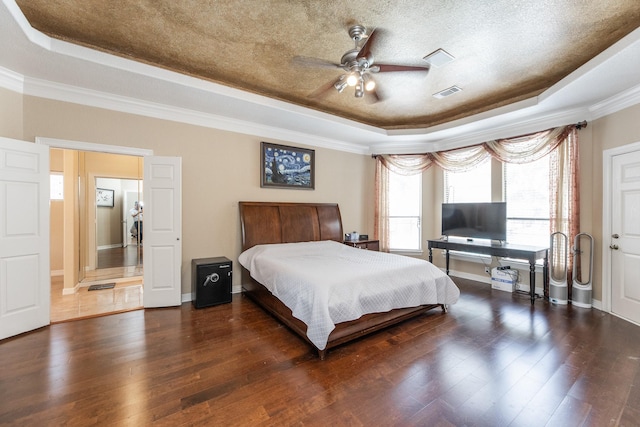 16206 Lobo Ln, Spring, TX 77379 - bedroom featuring a tray ceiling, ornamental molding, wood finished floors, a textured ceiling, and baseboards