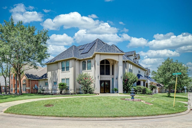 16206 Lobo Ln, Spring, TX 77379 - french country home featuring stucco siding, a front lawn, solar panels, and a shingled roof