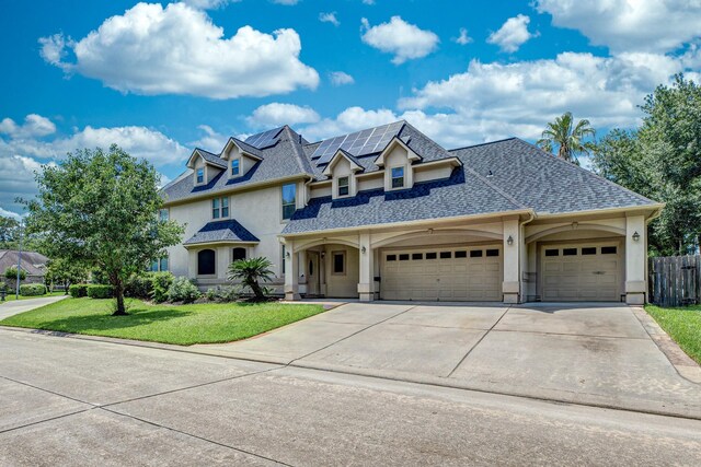 16206 Lobo Ln, Spring, TX 77379 - view of front facade with a garage, stucco siding, driveway, solar panels, and roof with shingles