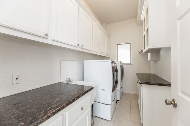 16206 Lobo Ln, Spring, TX 77379 - laundry room featuring washing machine and clothes dryer, cabinet space, light tile patterned floors, and baseboards