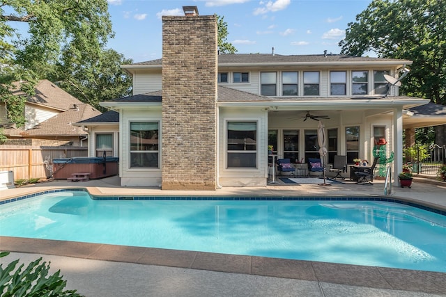 3407 Gold Candle Dr, Spring, TX 77388 - rear view of property featuring a hot tub, a patio area, a chimney, a ceiling fan, and roof with shingles