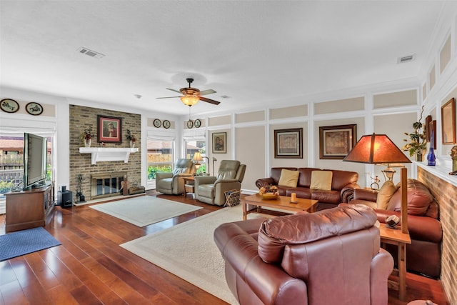 3407 Gold Candle Dr, Spring, TX 77388 - living room with a brick fireplace, plenty of natural light, wood finished floors, ceiling fan, and a decorative wall