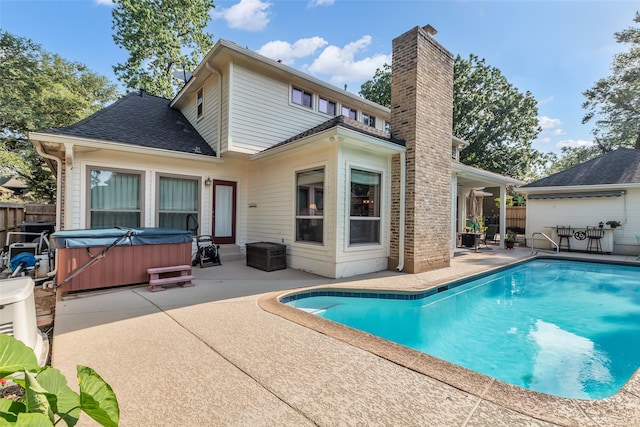 3407 Gold Candle Dr, Spring, TX 77388 - back of property featuring a hot tub, a patio, a chimney, and a shingled roof