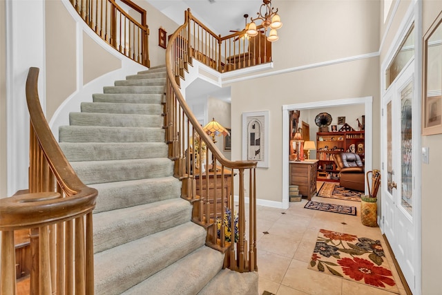 3407 Gold Candle Dr, Spring, TX 77388 - entryway featuring a high ceiling, stairway, light tile patterned floors, a chandelier, and baseboards