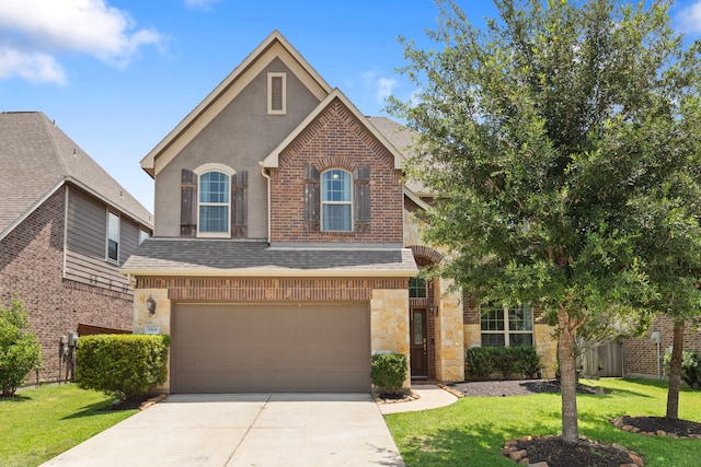 9414 Peralta Creek Ct, Cypress, TX 77433 - view of front of house with a front lawn, concrete driveway, a garage, stone siding, and roof with shingles