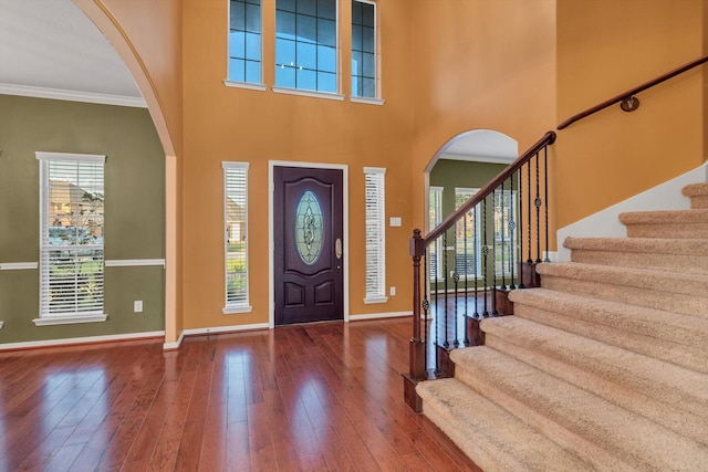 2402 Leslie Ln, Deer Park, TX 77536 - foyer entrance with arched walkways, baseboards, crown molding, hardwood / wood-style floors, and stairway