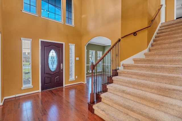 2402 Leslie Ln, Deer Park, TX 77536 - entryway with arched walkways, baseboards, a towering ceiling, wood-type flooring, and stairs
