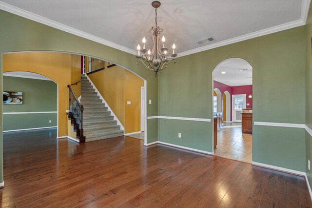 2402 Leslie Ln, Deer Park, TX 77536 - empty room featuring arched walkways, baseboards, crown molding, hardwood / wood-style flooring, and a chandelier