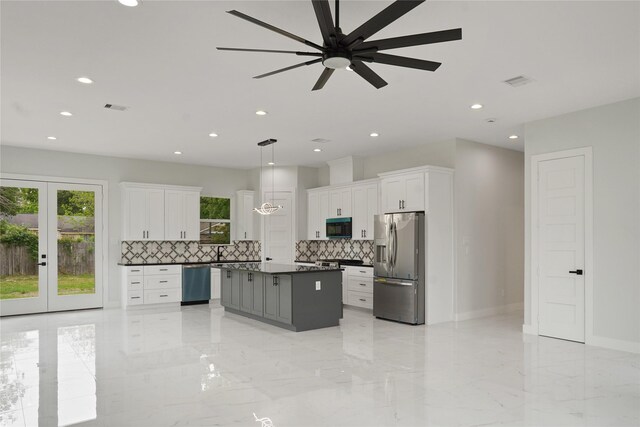511 Laurel St, La Marque, TX 77568 - kitchen with stainless steel fridge, black microwave, dark countertops, dishwashing machine, and decorative backsplash