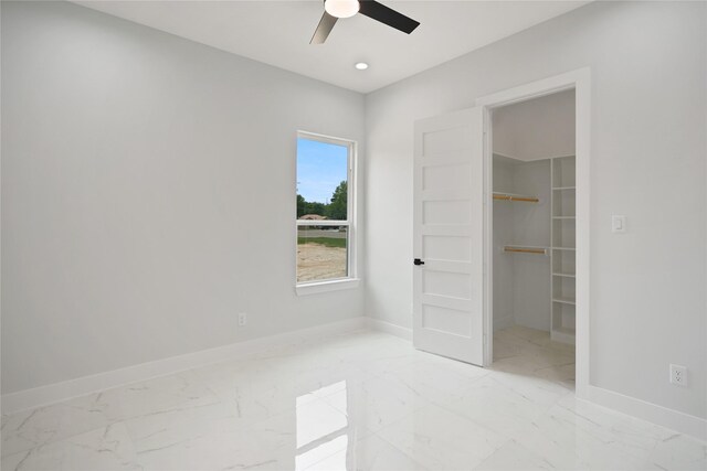 511 Laurel St, La Marque, TX 77568 - unfurnished bedroom featuring light marble finish floors, a walk in closet, baseboards, a ceiling fan, and a closet