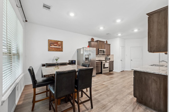 19018 Cicerone Ct, New Caney, TX 77357 - dining room featuring light wood-type flooring, recessed lighting, and baseboards