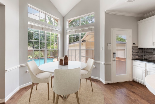 51 N Frosted Pond Dr, The Woodlands, TX 77381 - dining area featuring wood finished floors, healthy amount of natural light, vaulted ceiling, baseboards, and ornamental molding